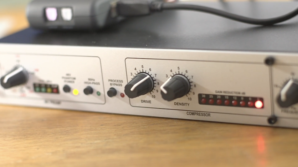 This is an image of the silver DBX 286S Microphone Processor (Close Up) on a wooden table.