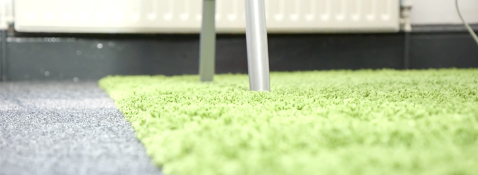 This is an image of a green Carpet that looks like grass or moss. There are silver chair legs visible in the image.