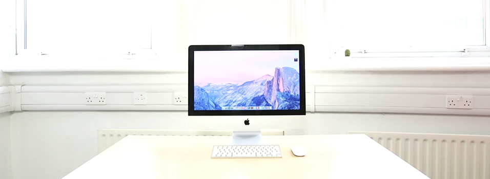 This is a white backdrop with white radiators. It shows a Mac Computer Desktop with a purple and blue desktop screensaver.