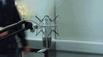 This is a gif a white man connecting a microphone with a Macbook. The gif just shows the mic getting plugged in.