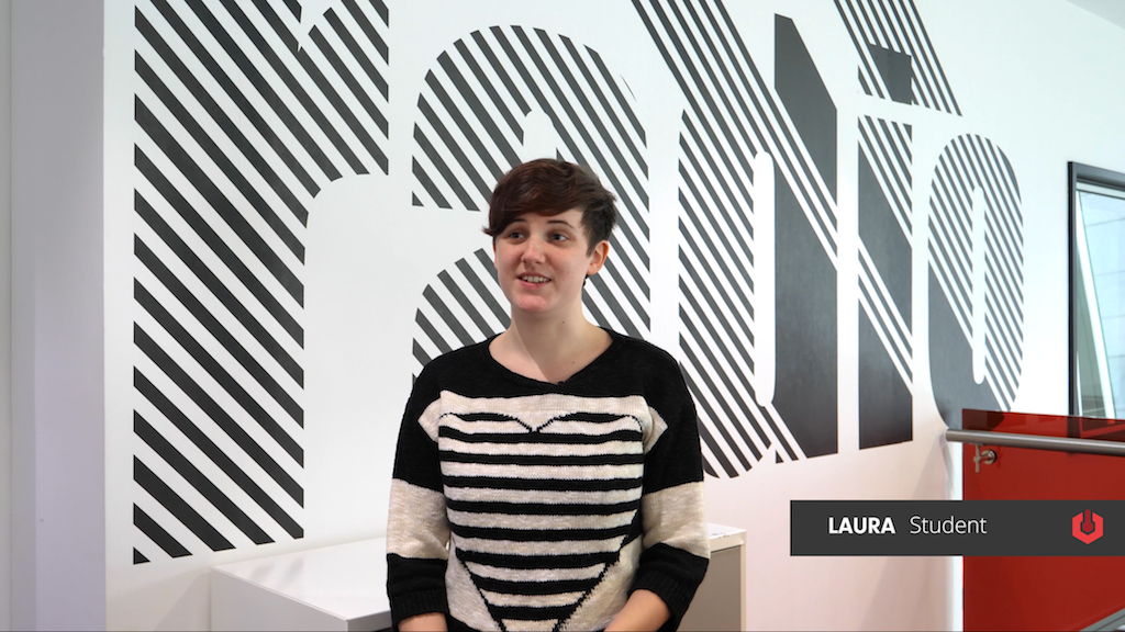 Image shows the Salford University student Laura, sitting in the media department.